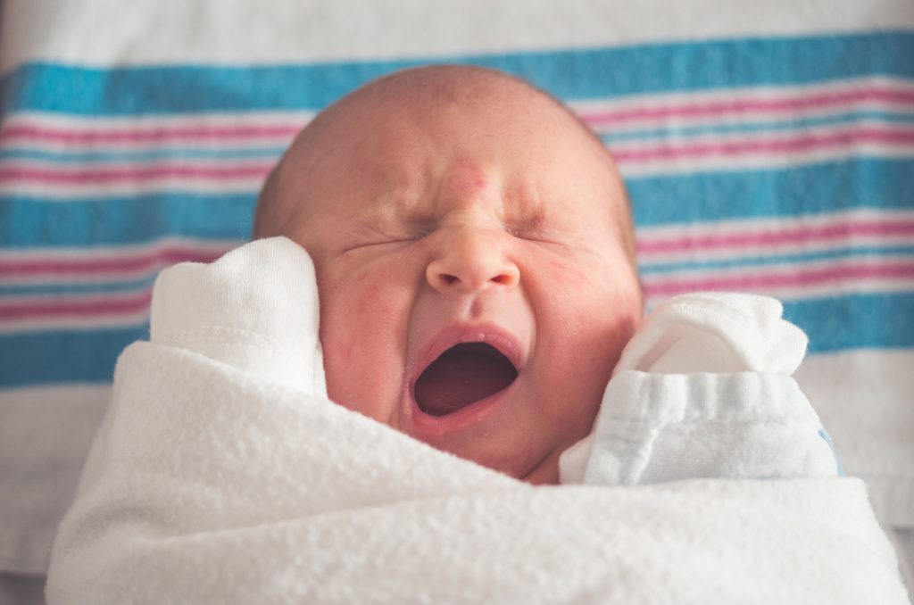 noworodek tuż po porodzie leży owinięty w pieluszki